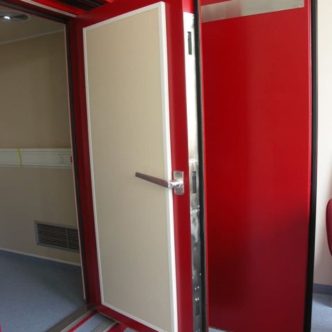 Außenansicht auf eine rote Hörkabine mit offener Tür